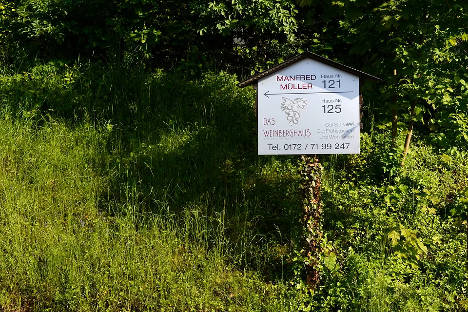 Wegweiser am grünen Wegrand: Das Weinberghaus, Haus Nr. 125 – gut schlafen, gut frühstücken und wohlfühlen