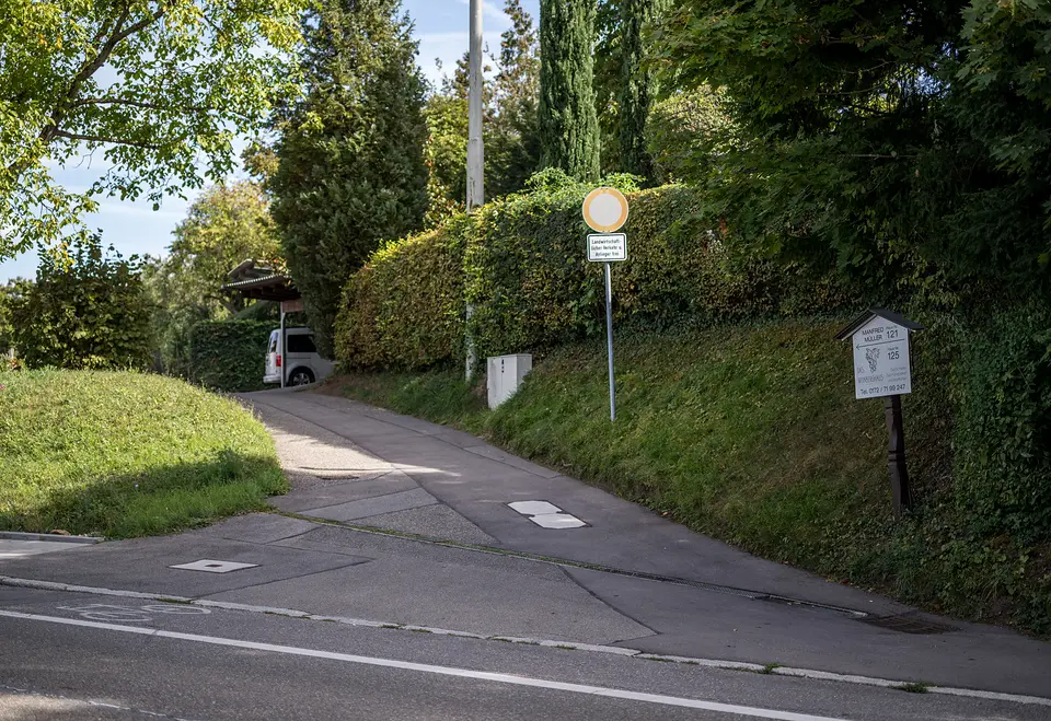 Einfahrt zum Weinberghaus von der Untertürkheimer Straße in Fellbach, mit Wegweiser am Hang