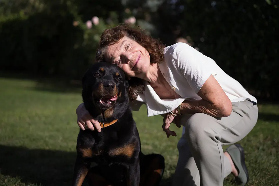 Hanne Petzold und der Rottweiler Wange an Wange auf dem Rasen im Garten