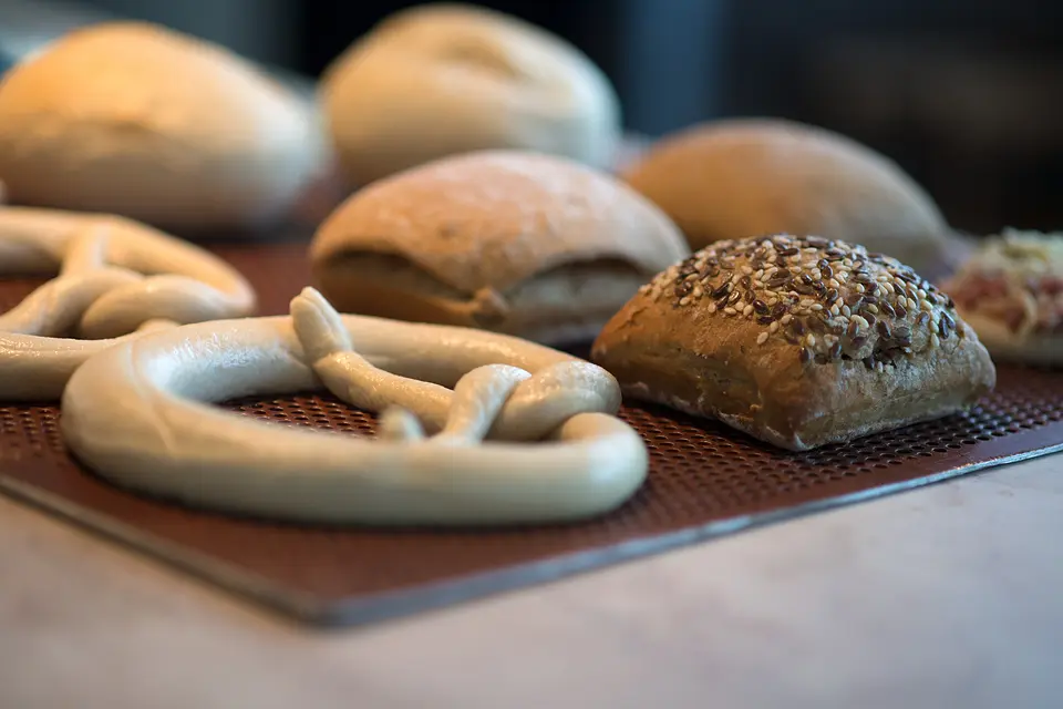 Frisch gebackene Brezeln, Brötchen und Körnerbrötchen auf dem Backblech