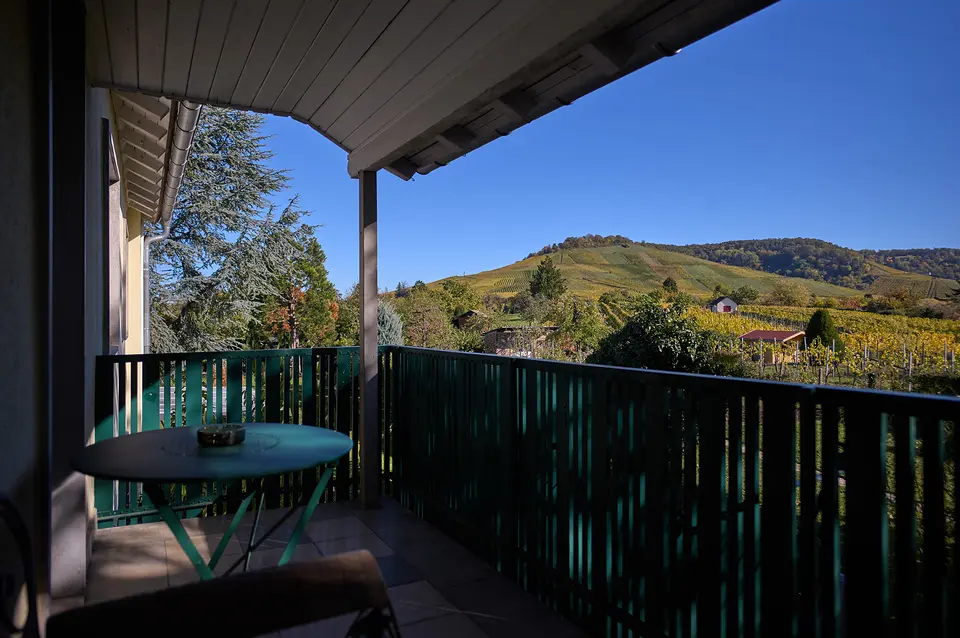 Balkon des Grünen Zimmers mit Bistrotisch, Blick über die herbstlichen Weinberge auf den Kappelberg