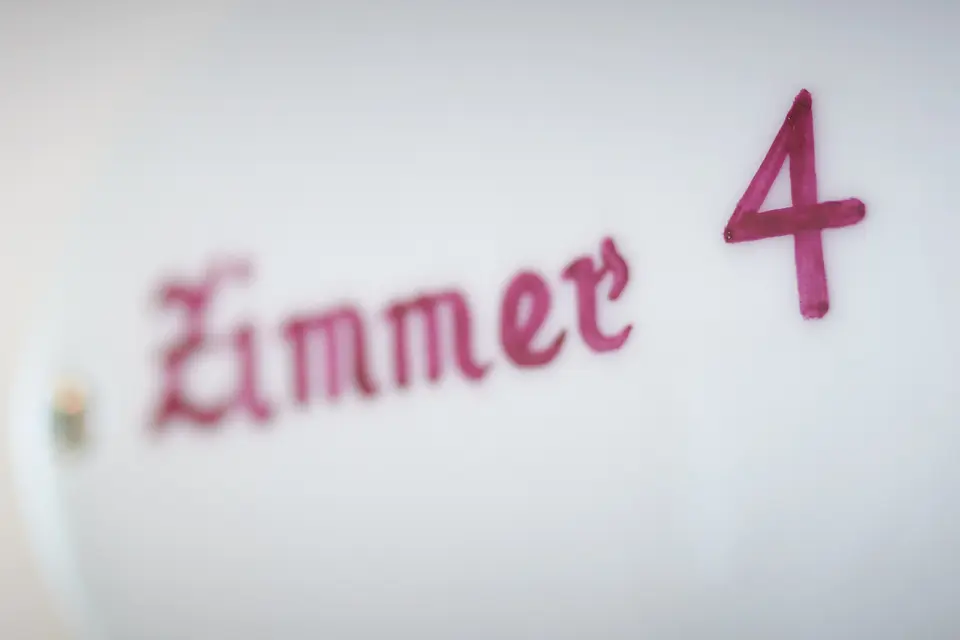 Türschild „Zimmer 4“ in roter Schrift – das Weinberg-Zimmer