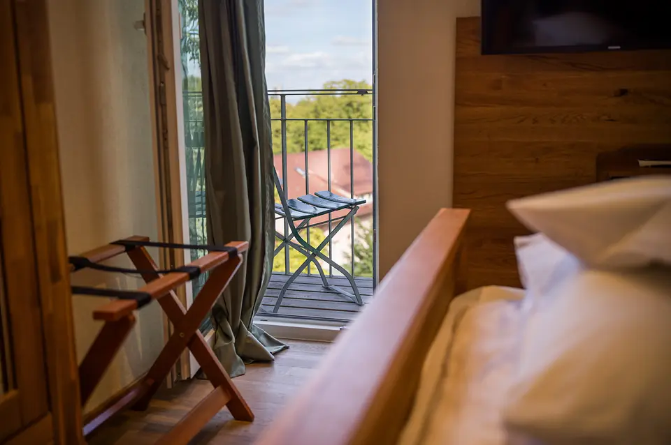 Gepäckablage und Balkontür des Weinberg-Zimmers mit Blick auf den kleinen Sitzbalkon